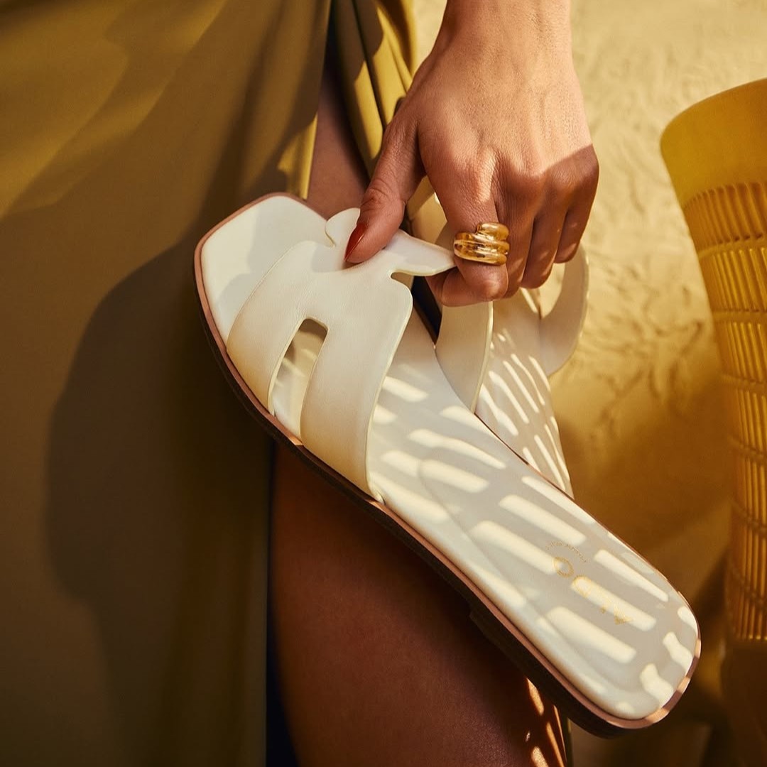 Aldo hand holding a slipper